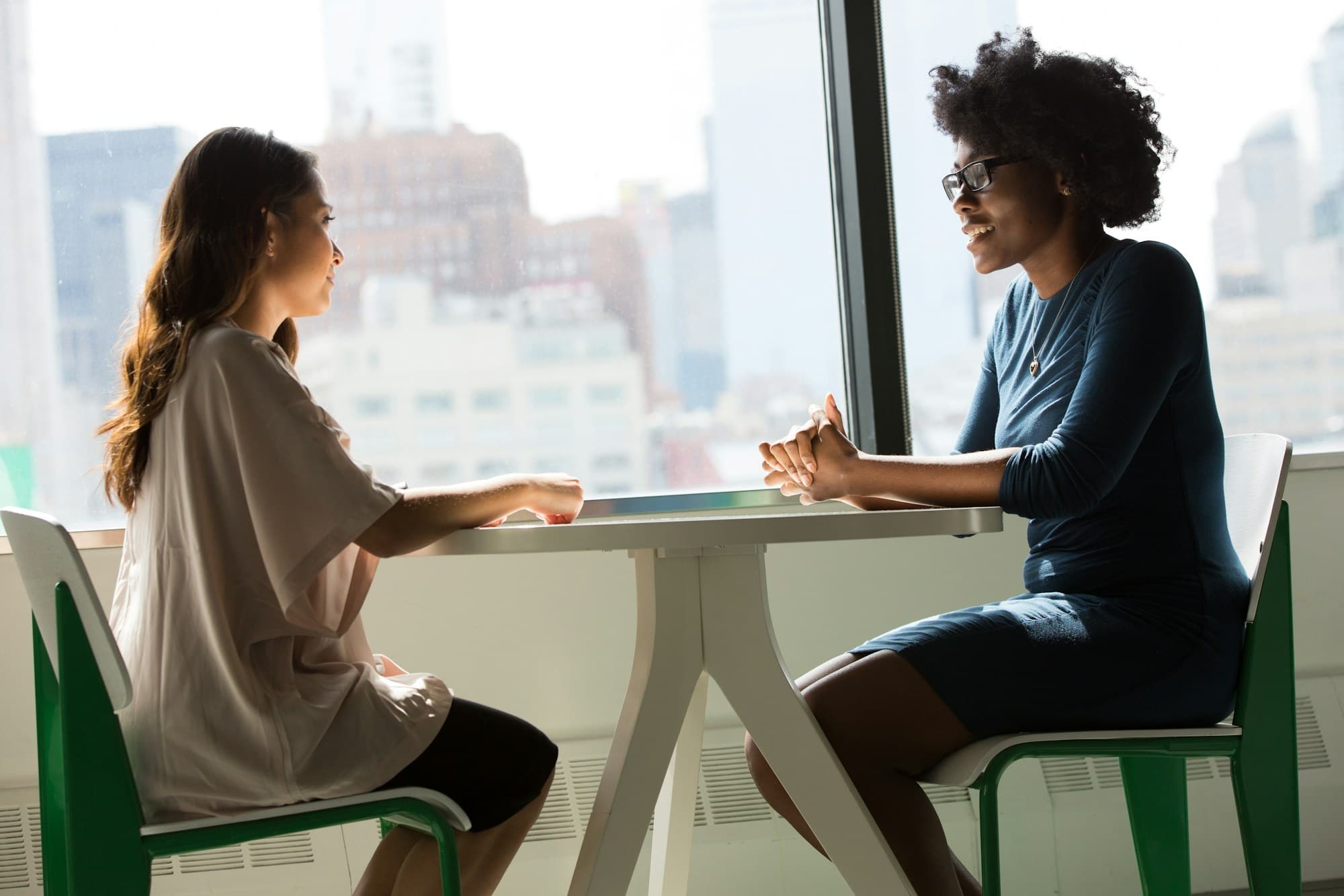 A consultant and a candidate in conversation at a table by the window